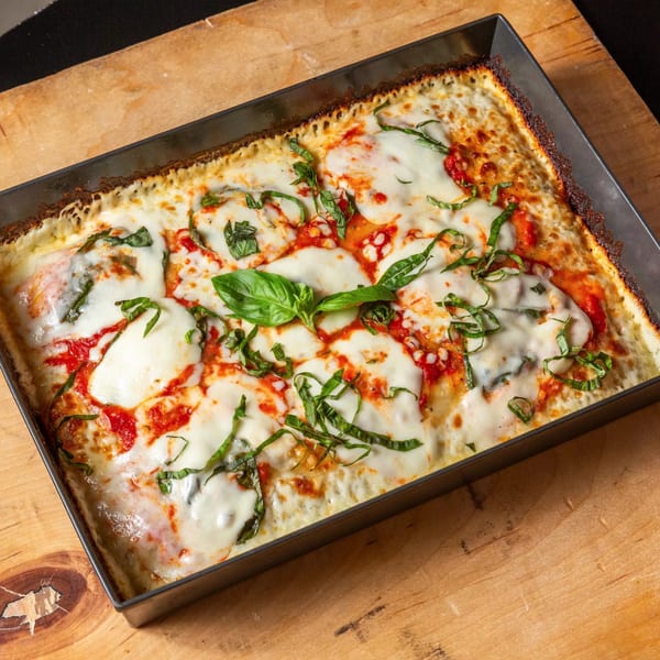 Main Street Pizza's rectangular Detroit-style pizza with melted mozzarella, red sauce, and fresh basil.
