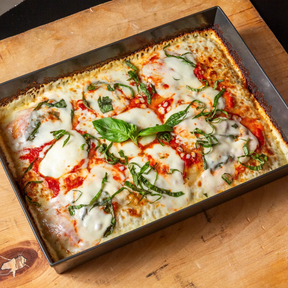 Main Street Pizza's rectangular Detroit-style pizza with melted mozzarella, red sauce, and fresh basil.
