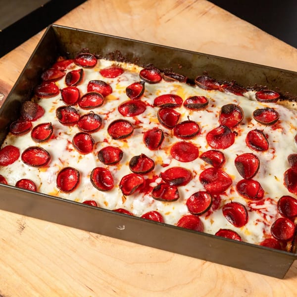 Main Street Pizza's Detroit-style pizza, with crispy pepperoni cups and melted cheese in a rectangular pan.